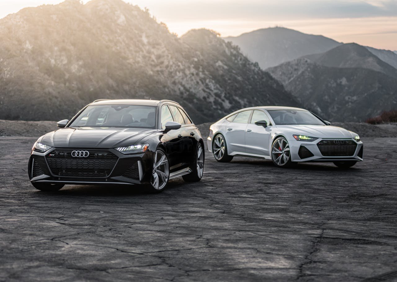 Crafting Captivating Headlines: Your awesome post title goes here Two luxury Audi RS models parked on a scenic mountain road at sunset.